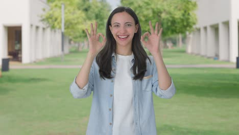 una chica india feliz mostrando una señal de bien