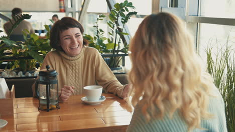 jóvenes amigas compartiendo momentos y hablando en una cafetería