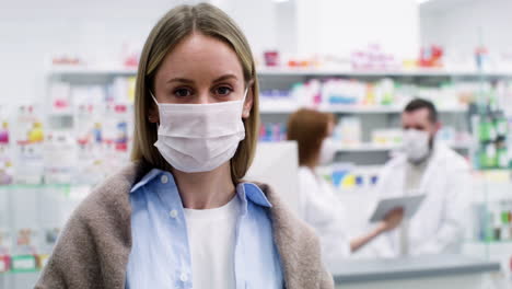 mujer con mascarilla médica en la farmacia