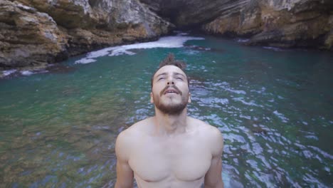 hombre respirando profundamente en la playa junto al mar.
