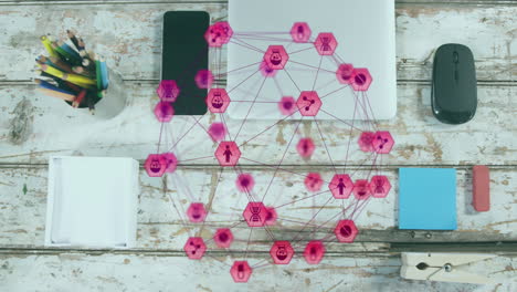 animación de un globo de iconos digitales contra un primer plano de equipos en una superficie de madera