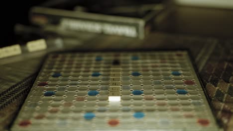 A-camera-slowly-tilts-up-as-the-focus-racks-across-an-old-scrabble-board-so-that-letters-spelling-out-the-words-'Science'-become-progressively-revealed,-coming-to-rest-so-that-spare-tiles-are-in-focus