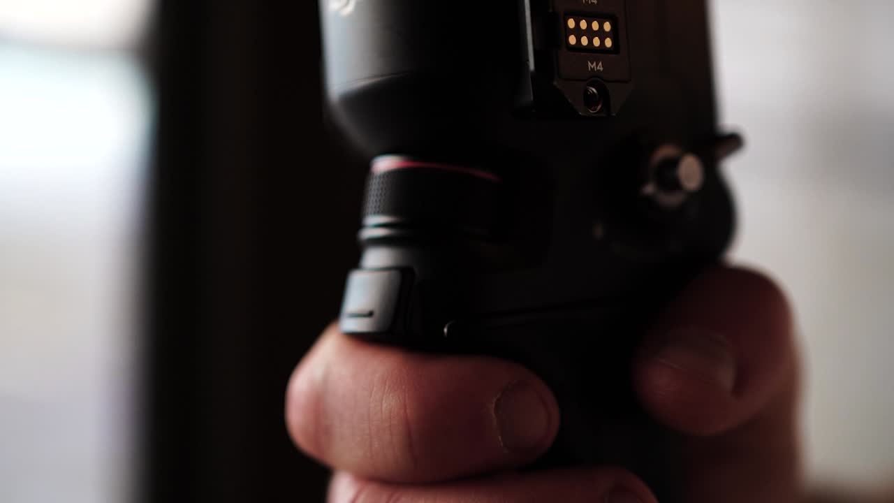 pessoa segurar estabilizador gimbal eletrônico e fazer duplo clique no botão