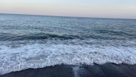 Landscape-of-a-beach-on-the-coast-of-the-Costa-del-Sol,-with-calm-waves-on-the-shore-before-a-beautiful-sunset