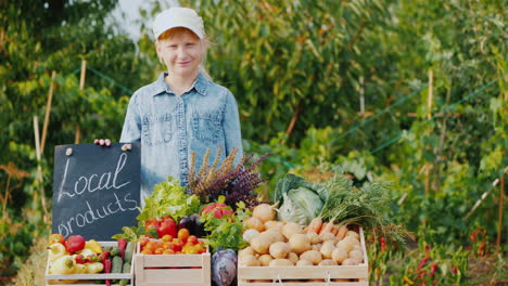 A-Kid-Farmer-Stands-By-The-Vegetable-Counter-At-The-Farmer\'s-Market