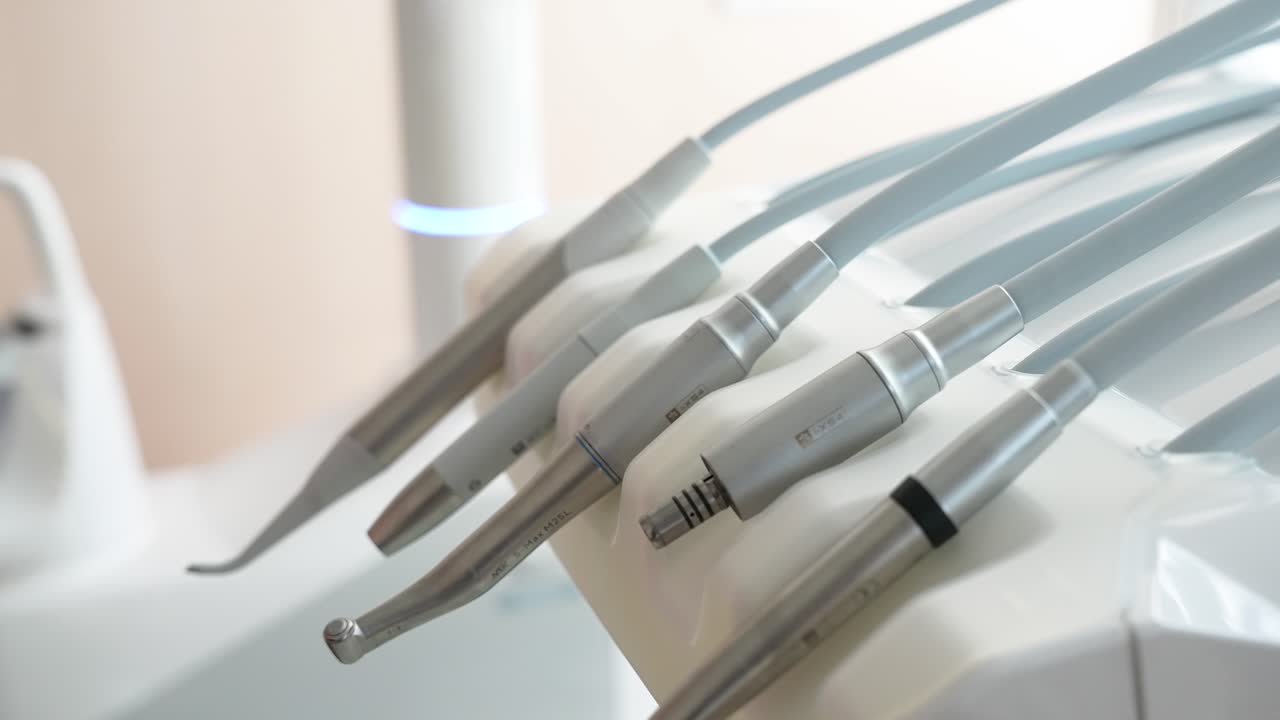 最新のクリニックにおける先進的な歯科医療器具の詳細。明るい照明設定が、洗練された金属製のデザインと精密なエンジニアリングを際立たせ、ヘルスケアプレゼンテーションに最適です。