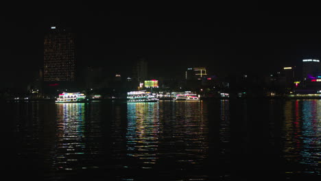 cruise lit with colorful lights sailing across han river in da nang city, vietnam, wide angle shot
