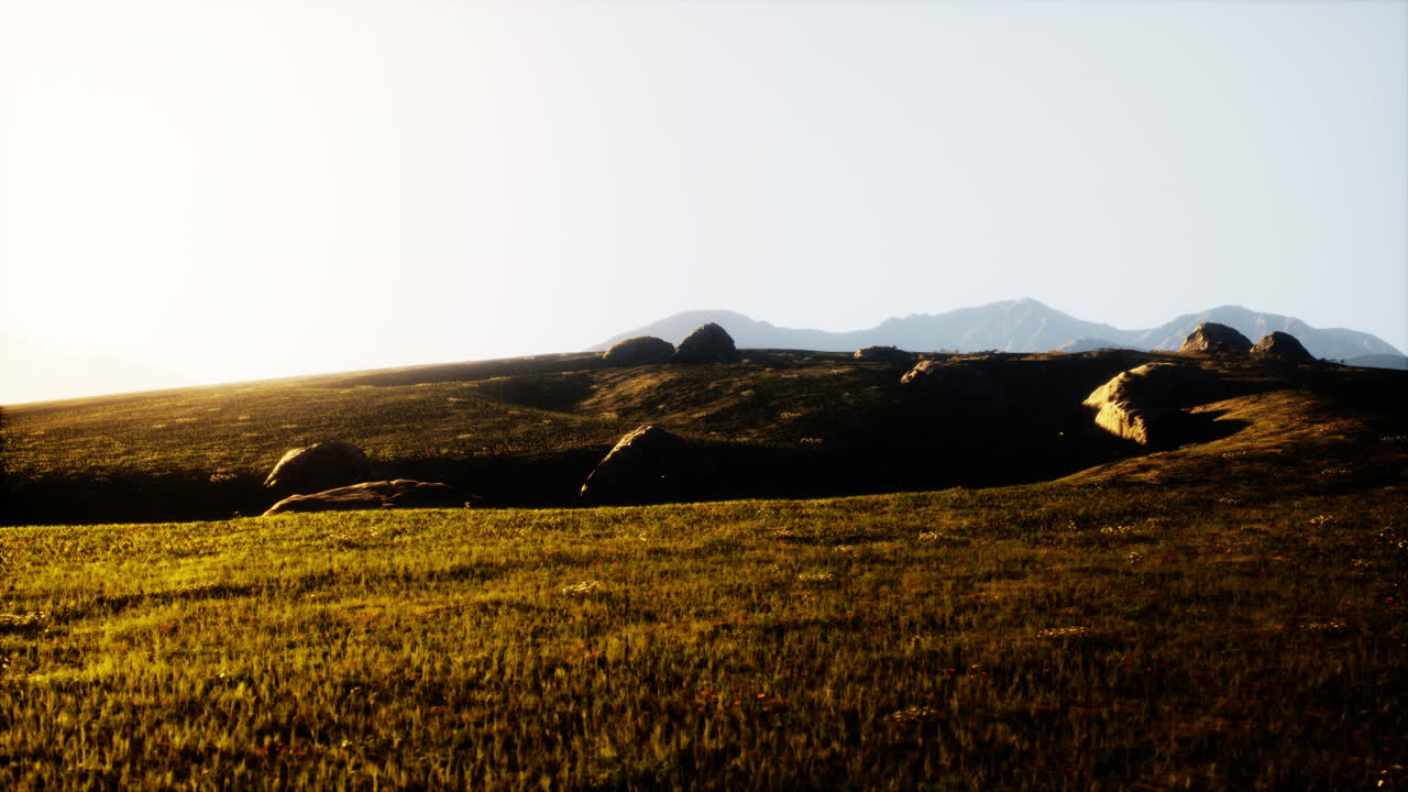 앞면 에 잔디 이 있는 산맥 위 에 해가 지는 것