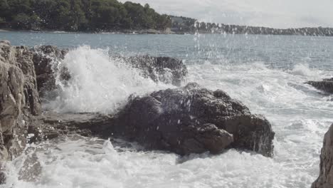 croatian ocean seascape scene with waves breaking on volcanic grey rocks on the coastal line of pula