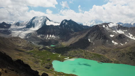 revelador disparo de dron de 3 hombres parados en la cima de una montaña sobre el lago ala-kol en kirguistán