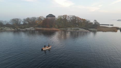 two fishermen standing on their boat trying to catch some fish in the beautiful archipelago in the naval city of karlskrona, sweden-1