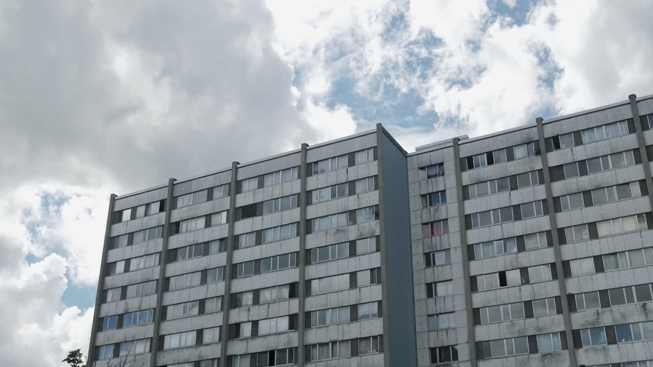 Wide shot of social housing buildings in Nieuw Gent, Belgium, under a cloudy sky, reflecting urban life