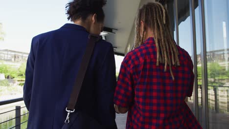 twee diverse mannelijke vrienden die op straat lopen en naar een smartphone kijken