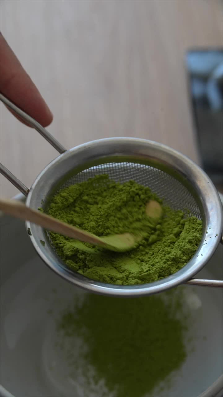 Matcha powder being sieved into a bowl
