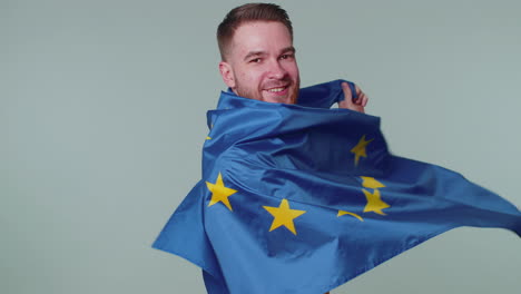 man waving european union flag, smiling, cheering democratic laws, human rights, freedoms in europe