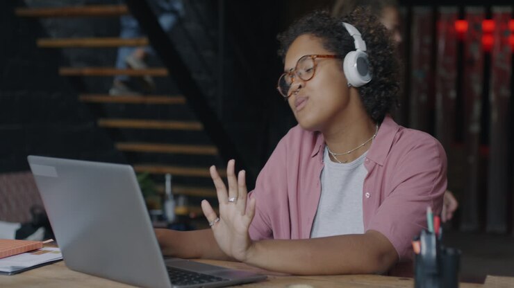 Mujer escuchando música mientras trabaja en su portátil