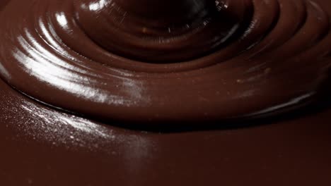 pouring melted liquid premium dark or milk chocolate with nuts, confectioner prepares dessert, icing