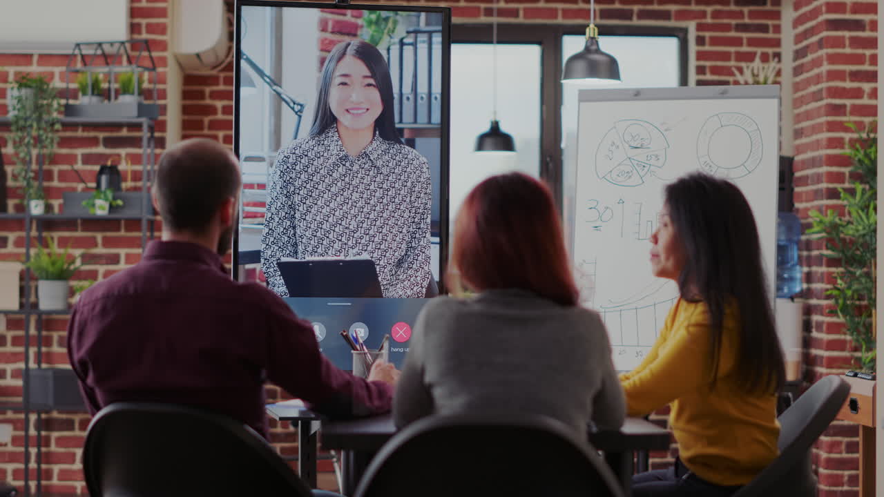 Group of coworkers using video call communication in boardroom