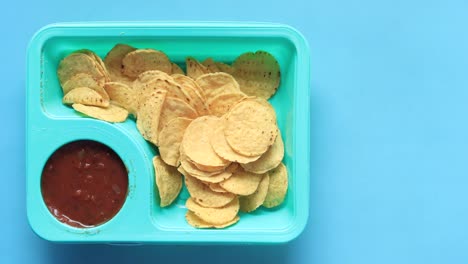 papas fritas de tortilla con salsa en una bandeja azul
