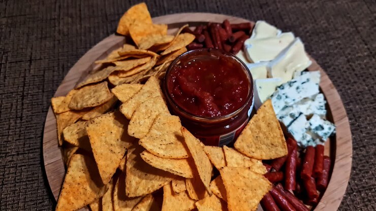 Assorted snacks and chips arranged on table, creating a warm, relaxed evening atmosphere