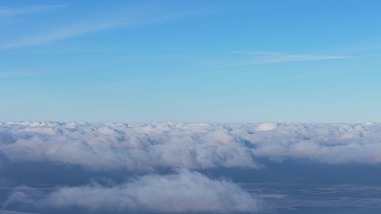 Expansive cloudscape under a bright blue sky, evoking serenity and wonder