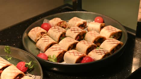 trozos de pollo y carne de shawarma envueltos en pan de tortilla a la parrilla