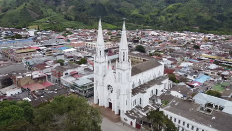 aerial view of a white church with twin spires in a town nestled in a mountainous landscape