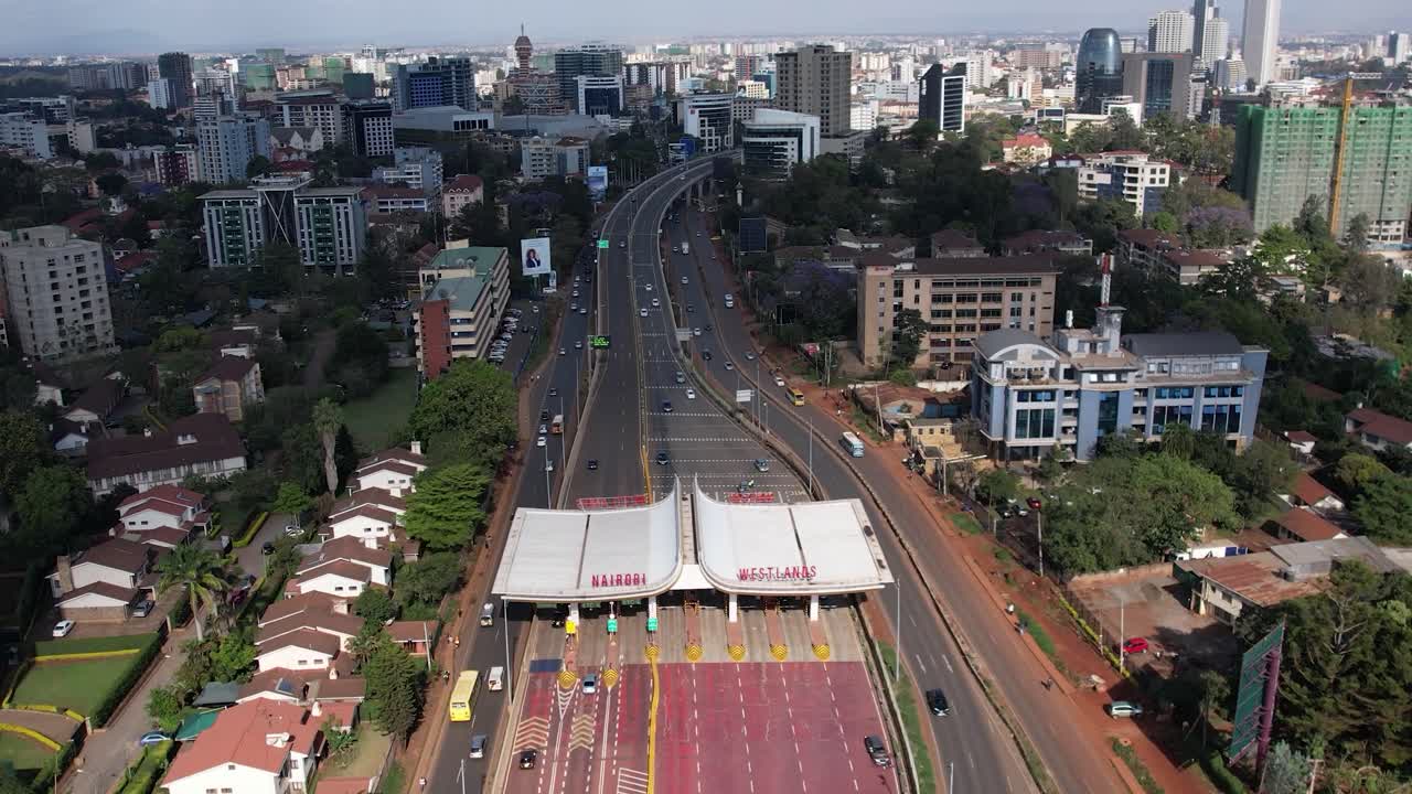 A beautiful aerial drone footage of the city of Nairobi, Kenya, showcasing the bustling urban office spaces, modern residential areas, the Nairobi Expressway, and Waiyaki Way. Captured during the day