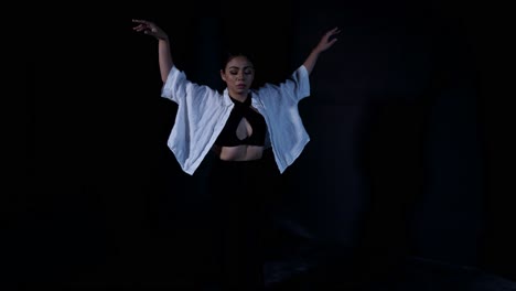 Beautiful-Young-Woman-Dancing-Whacking-in-Serene-Release-in-Dramatic-Dark-Background