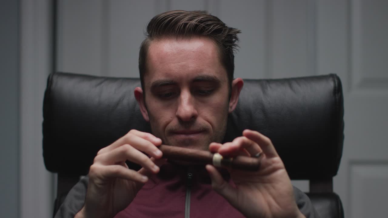 hombre inspeccionando un cigarro cubano