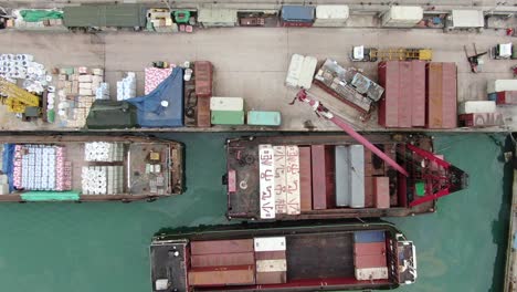 pequeñas barcazas de contenedores de tipo alimentador que operan en el muelle de pilar de hong kong