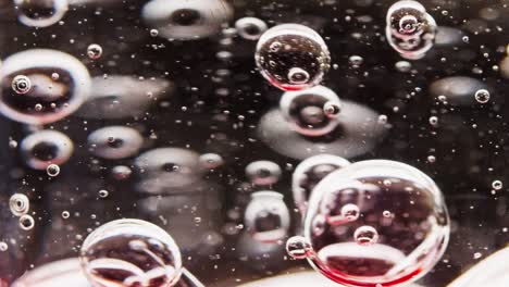 macro shot of red bubbles being mixed in water