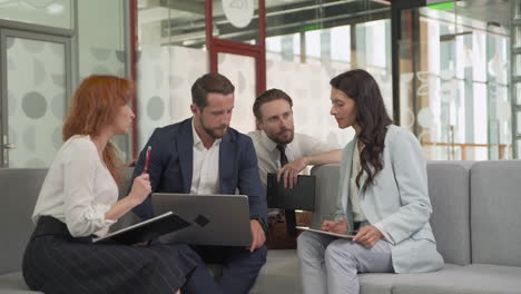 Work-Team-Composed-Of-Two-Females-And-Two-Males-Around-A-Laptop-Put-Issues-In-Common