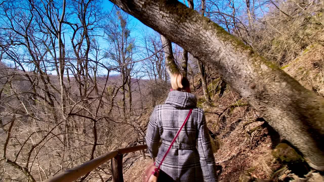 plano medio de mujer caminando por el sendero en las montañas