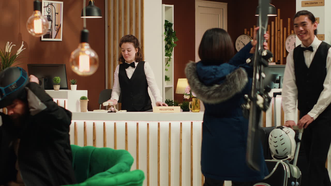 아시아 관광객 이 리셉션 직원 과 대화 하고 있다