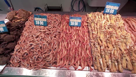 different varieties of sea food displayed on the table in the market pan shot from left to right