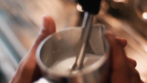 Coffee machine pouring milk into cup