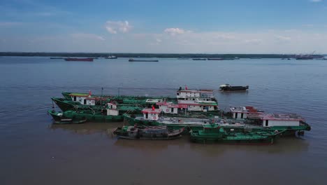 toma de órbita aérea de barcos de trabajo anclados cerca de la costa en un día claro y soleado