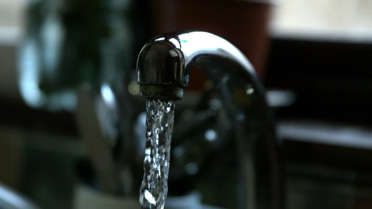 agua que fluye de un grifo de cromo