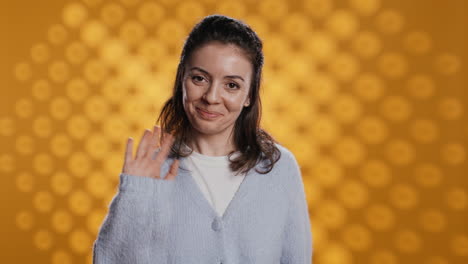 cheerful woman happily doing salutation hand gesture, studio background