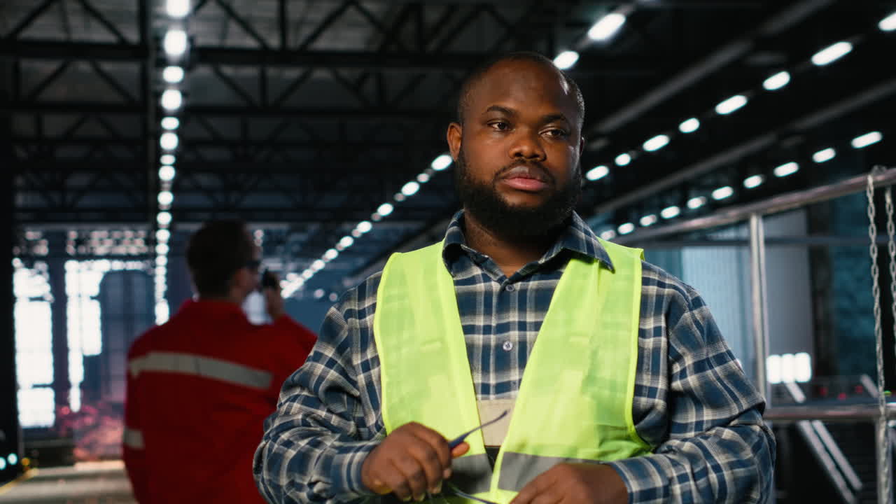 Black worker in a plant overseeing steel manufacturing with automation equipment