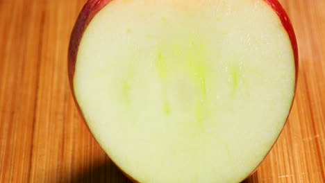 sharp knife cuts a slice from a fresh red apple, macro shot detail close up in 4k