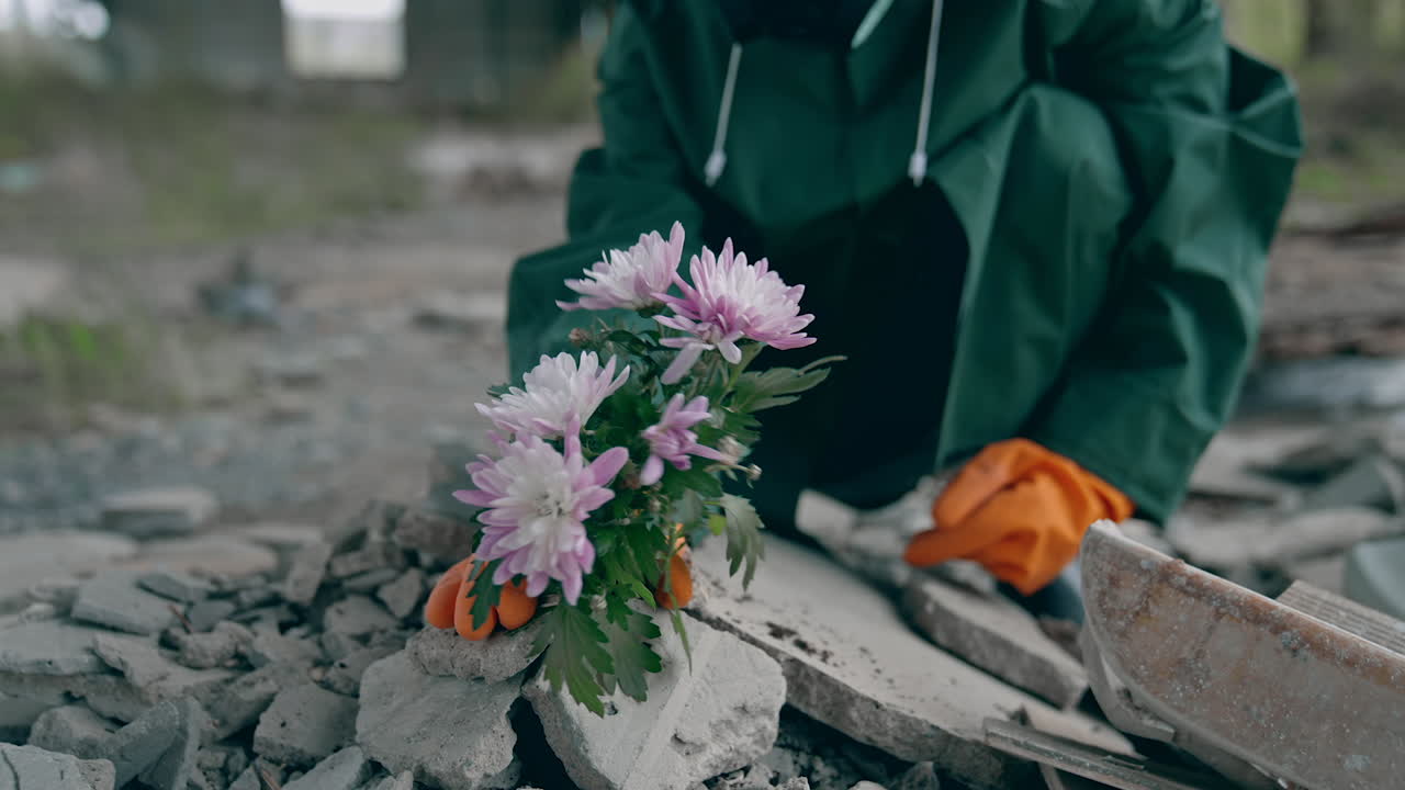 Ecologist saving flowers in dangerous zone. Man in hazmat suit and protective gloves pulling out bunch of flowers in polluted place. Environmental disaster.