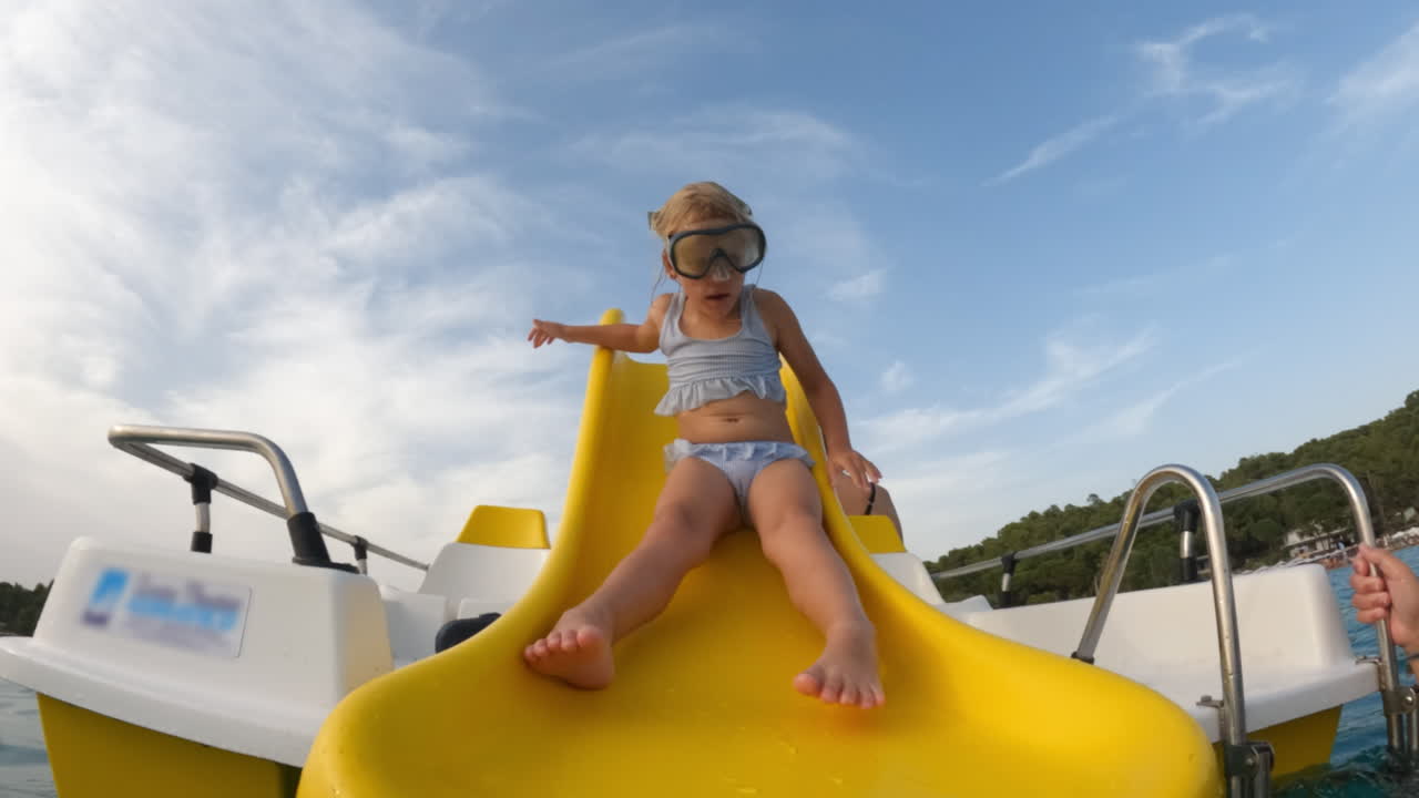 niña pequeña divirtiéndose en un tobogán de agua