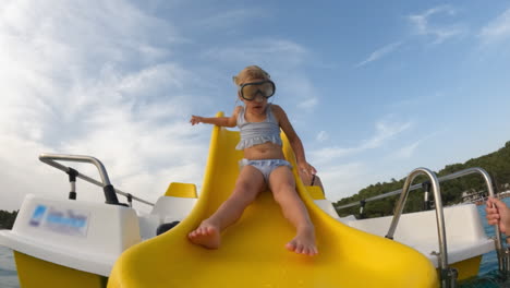niña pequeña divirtiéndose en un tobogán de agua