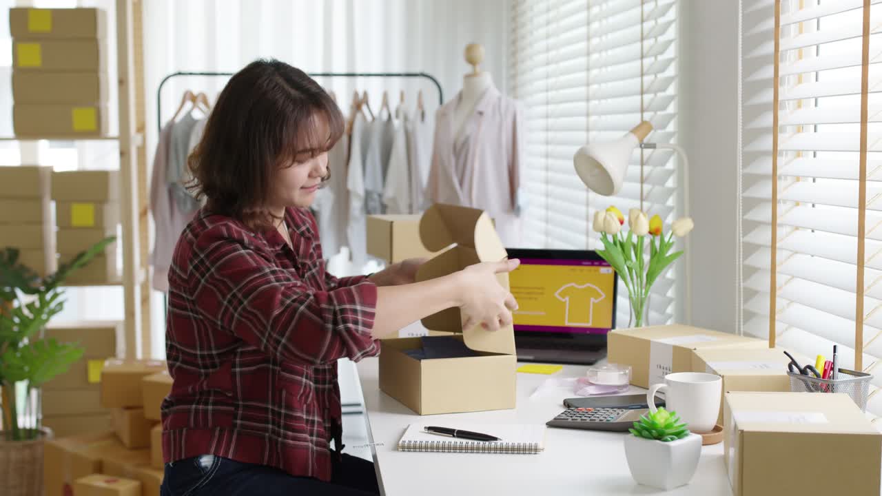 젊은 매력적인 아름다운 스터 아시아 여성 포장 제품 소규모 비즈니스 패키지 주문 온라인 소매 상점 고객에게 배달. sme 소유자는 가정 사무실에서 dropshipping 상자를 준비하는 작업.