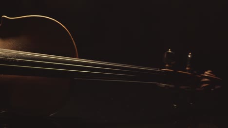 close up of old violin, dramatic light changes over the instrument , classical symphony music video footage