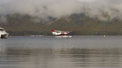 floatplane taxiing on calm lake te anau in new zealand