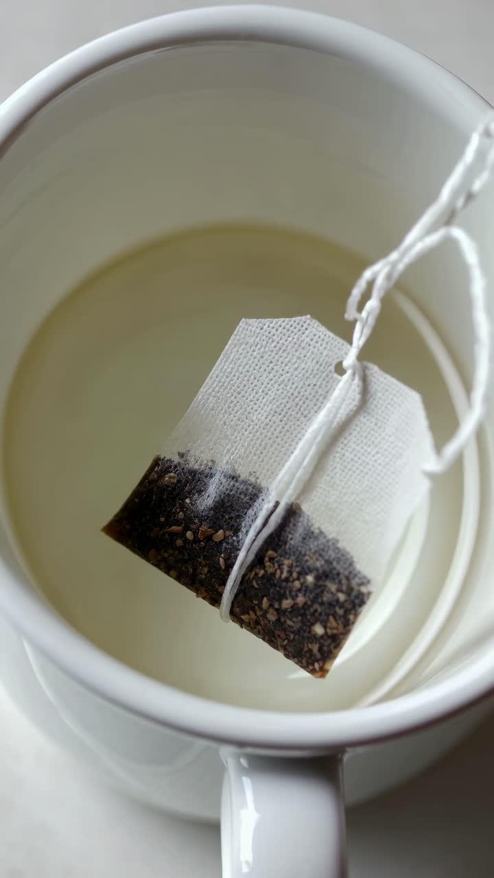 Close-up angle of a tea bag steeping in a white cup, capturing the serene moment
