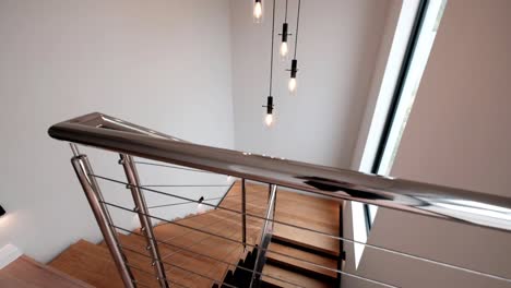 modern interior staircase with industrial lights, stainless steel balustrade and wooden treads